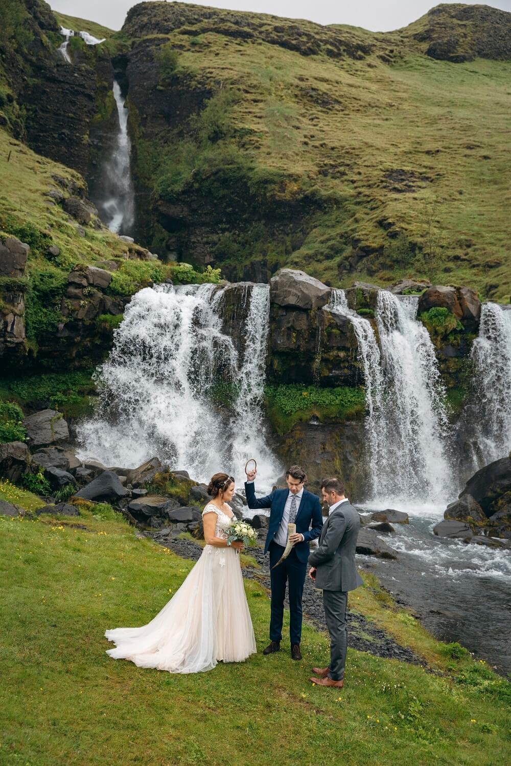 A wedding couple gets married in a pagan ceremony in front of Gluggafoss waterfall.