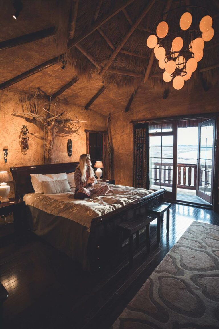 Photographer Ása Steinars sits on the King bed in the Africa Suite at Hotel Rangá.