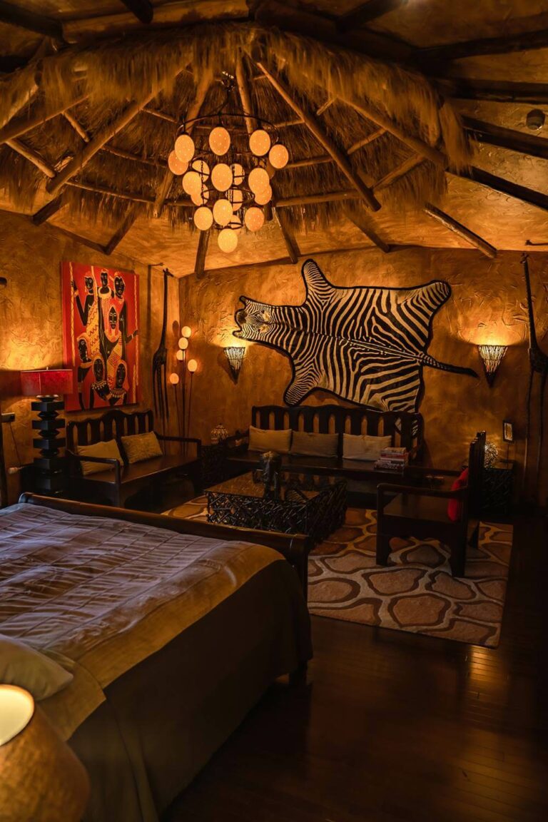 Hotel Rangá's Africa Suite decorated with a King size bed, zebra skin wall hanging, wooden furnishings, a painting of native Africans and more.