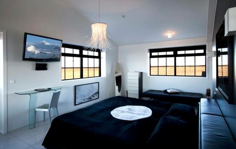 A King size bed and black and white furnishings in the Hotel Rangá Antarctica Suite.
