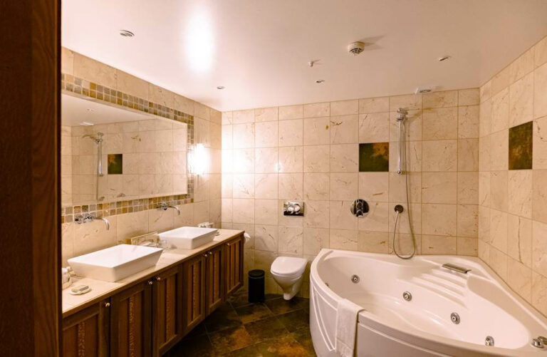 Bathroom in Hotel Rangá's Australia Suite featuring a large soaking tub, toilet and two sinks.