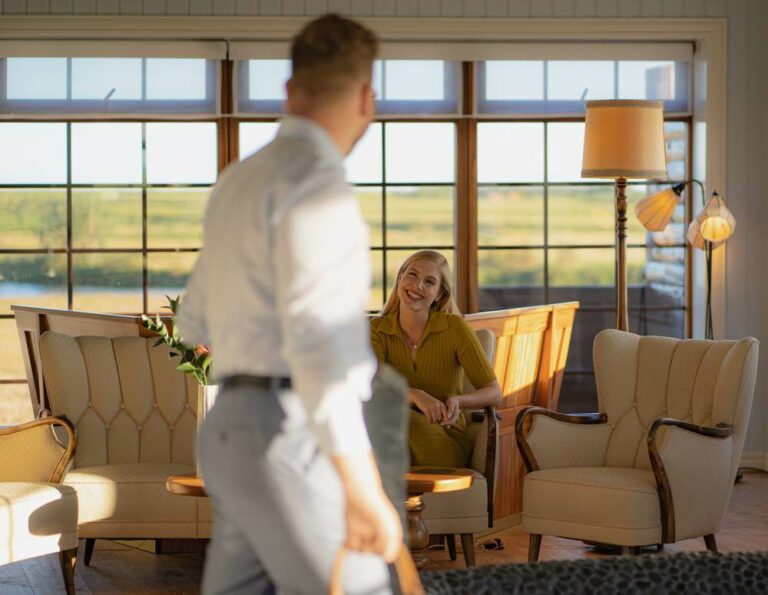 Woman sits and man stands in Hotel Rangá's Icelandic Suite featuring traditional Icelandic furniture.