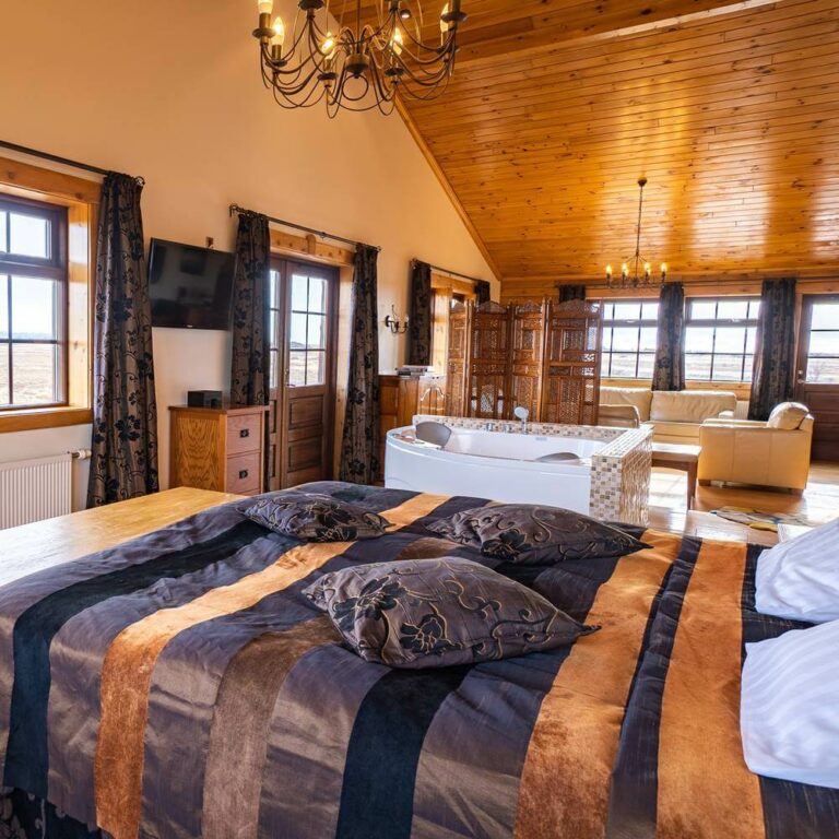 Hotel Rangá's Royal Suite, a spacious hotel room filled with a large soaking tub, a King bed and leather sofas.