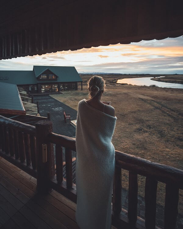 Woman standing on a balcony looking out onto Hotel Rangá and the Rangá River.